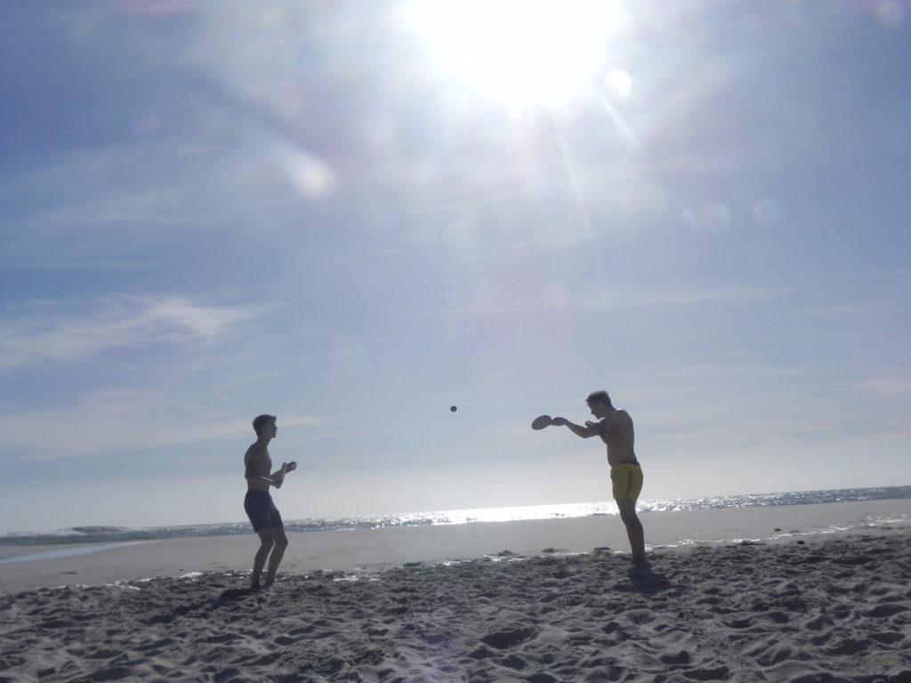 Boys playing bat and ball on the beach in Cape Town